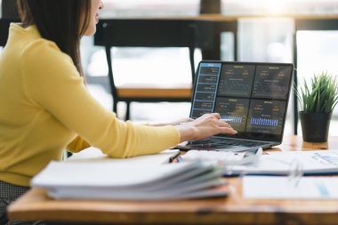 Danışman finansal iş analizi kadın analiz ekibi veri tablolarını, grafikleri ve dizüstü bilgisayardaki gösterge panelini inceliyor. Veri analiz kavramı.