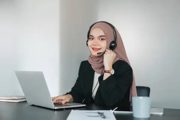 Asian muslim operator woman agent with headsets working in a call centre