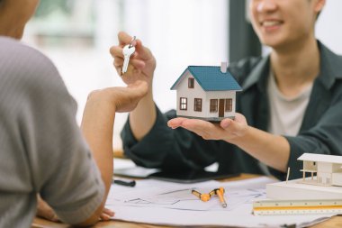 Emlakçı, yaşlı bir kadına ev sahipliği ve hayat sigortası, emlak yatırımı ve ev kredisi finansmanı kavramları sunuyor