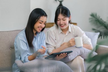 İki bin yıllık Asyalı kadın girişimciler dijital dizüstü bilgisayarda birlikte çalışıyorlar.