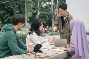 Kampüste birlikte çalışan çok ırklı üniversite öğrencileri grubu.