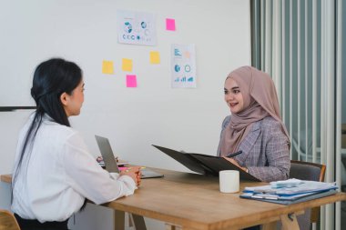 Dost canlısı Müslüman insan kaynakları müdürü ofis yönetim kurulunda genç bir bayanı sorguluyor. Kariyer ve adam toplama konsepti.