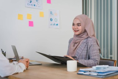 Dost canlısı Müslüman insan kaynakları müdürü ofis yönetim kurulunda genç bir bayanı sorguluyor. Kariyer ve adam toplama konsepti.
