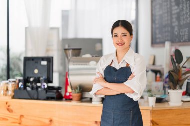 Cheerful small business owners smiling and looking at camera while standing in front of cafe entrance, welcomes guests. Business and entrepreneurs concept