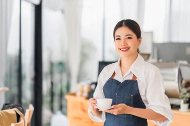 Cheerful small business owners smiling and looking at camera while standing in front of cafe entrance, welcomes guests. Business and entrepreneurs concept