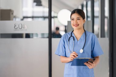 Confident smiling nurse holding medical lab patient health check form at hospital.