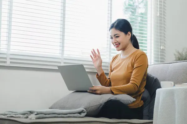 Cheerful Woman Video Calling Online via Laptop at home