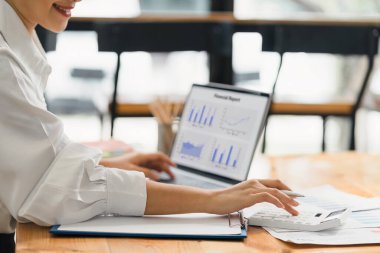 Bir veri grafiğindeki finansal yatırımları, iş ve pazarlama artışını analiz etmek için dizüstü bilgisayar kullanan bir iş kadını veya muhasebeci. Muhasebe, ekonomi ve ticari analiz kavramları