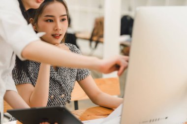 Bir ofiste istatistiksel bir rapor hazırlayıp mali verileri tartışan iki işadamı veya bir pazarlama ekibi, dizüstü bilgisayar ekranında veri tabloları, grafikler ve bir gösterge panelini inceliyor.