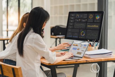 İş stratejisi için veri analiz paneli üzerinde çalışan iki veri analisti