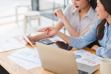 Finans uzmanları, hesap makinesi kullanarak ve bir dizüstü bilgisayardaki verileri ve çeşitli grafikleri tartışarak finansal analize giriştiler. İş Analizi Üzerine Dizüstü Bilgisayarla İşbirliği Yapan Ortaklar