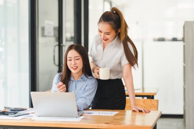 Veri tabloları, grafikleri ve istatistikleri analiz eden iki işadamı veya pazarlama ekibi ve bir istatistiksel rapor hazırlamak ve ofiste mali verileri tartışmak