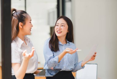Veri tabloları, grafikleri ve istatistikleri analiz eden iki işadamı veya pazarlama ekibi ve bir istatistiksel rapor hazırlamak ve ofiste mali verileri tartışmak