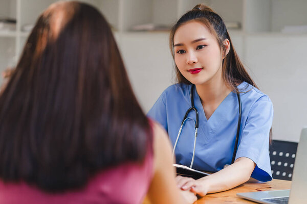 A nurse offers reassuring care by holding a patient's hand during a medical consultation, creating a supportive and empathetic atmosphere