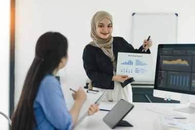 İki meslektaş modern ofis toplantısında pazarlama raporunu tartıştı