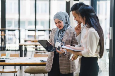 Gündüz vakti modern ofiste çeşitli takımlar iş birliği yapıyor.