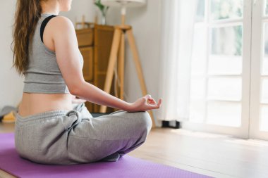 Asyalı genç bir kadın yoga yapıyor yoga, yoga ve spor egzersizleri yapıyor. Sağlıklı yaşam tarzı, sakinlik ve evde dinlenme..