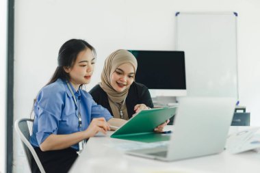 Genç insanlar finansal verileri ve pazarlama stratejilerini tartışıyor ve analiz ediyor, şirket kârlarını artırmak için sunuyor ve beyin fırtınası yapıyor