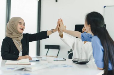 Neşeli ve çeşitli iş arkadaşları başarıyı kutluyor.