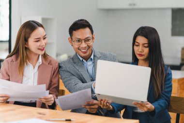 İş adamları dizüstü bilgisayar ve belge kullanarak proje üzerinde işbirliği yapıyorlar