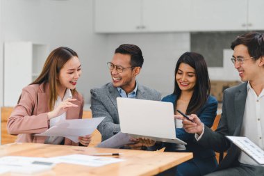 İş adamları dizüstü bilgisayar ve belge kullanarak proje üzerinde işbirliği yapıyorlar