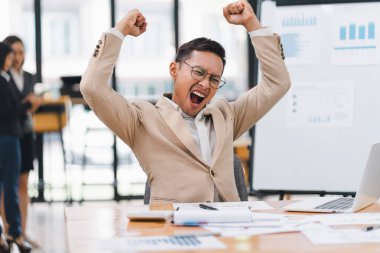 Mutlu Asyalı iş adamı zaferi kutluyor.