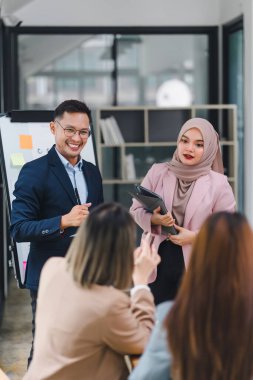 Modern ofiste toplantı sırasında veri grafiklerini ve grafiklerini sunan ve tartışan profesyonel iş ekibi