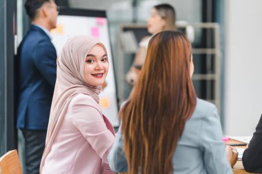 Modern ofiste toplantı sırasında veri grafiklerini ve grafiklerini sunan ve tartışan profesyonel iş ekibi