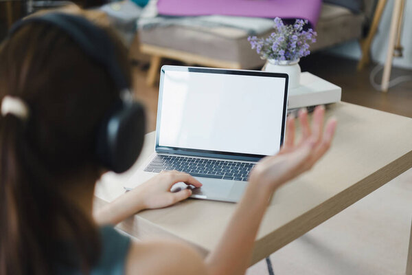 Woman on Video Call with Blank Laptop Screen. White screen for graphic montage.