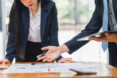 Toplantı sırasında mali belgeleri ve tabletteki verileri analiz eden iş adamlarının yakın plan görüntüleri