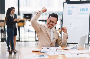 Bir işadamı toplantı odasında başarılı bir iş anlaşmasını kutluyor.