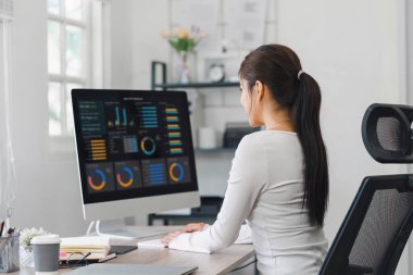 Veri iş analizi ve Veri Yönetimi Sistemi için bilgisayar monitöründe veri görselleştirmeleri kullanan profesyonel veri analisti