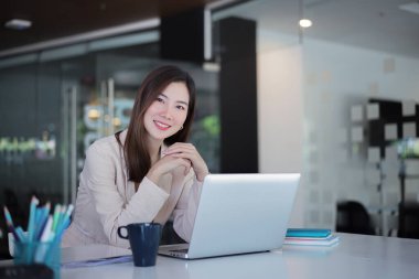 Masadaki belgeleri inceleyen Asyalı iş kadını..