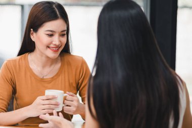 İki meslektaş iş raporlarını bir ofiste kahve içerken tartışıyor.