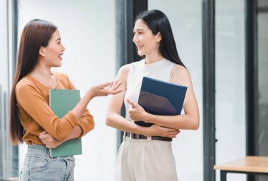 Modern ofisteki dokümanları incelerken tartışan iki iş kadını