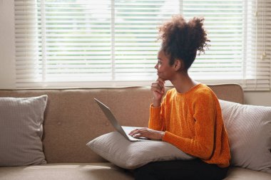 Dizüstü bilgisayar kullanan mutlu genç bir kadın Webinar seyrediyor, çevrimiçi çalışıyor, bilgisayar ekranı öğreniyor web dersleri alıyor ya da evden uzaktan kumandalı sanal arama görüşmesi yapıyor..