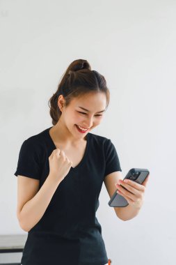 Dost canlısı gülümseyen kendine güvenen Asyalı kadın beyaz arka planda el ele tutuşmuş akıllı telefonu tutuyor.