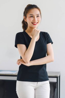 Dost canlısı gülümseyen kendinden emin Asyalı kadın beyaz arka planda kollarını kavuşturmuş duruyor.