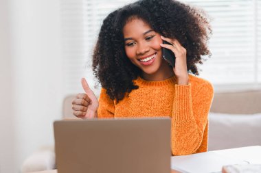 Gülümseyen Afrikalı Amerikalı Kadın Evde çalışırken telefonda konuşuyor