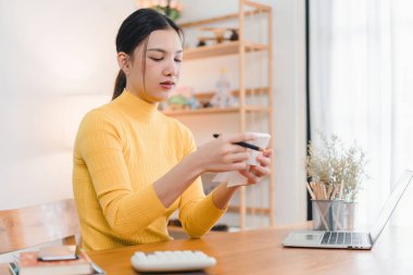 Evdeki mali işleri idare ederken hesap makinesi kullanan ve makbuzları tutan kadın