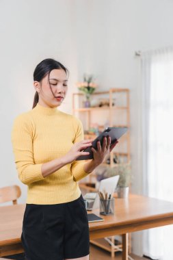 Masada dijital tablet üzerinde çalışan Asyalı kadın.