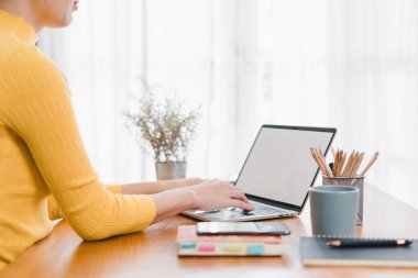 Beyaz ekran laptopuyla çalışan bir kadın..