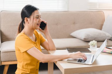 Evde dizüstü bilgisayar ve belgelerle çalışan genç bir iş kadını. İş hayatı dengesi kavramı.