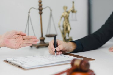 Yasal belge yakınlarda tokmak ve adalet terazisiyle imzalandı.