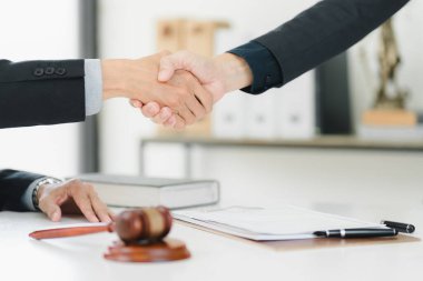 Profesyonel bir tokalaşma, yasal ortamda anlaşma ve işbirliğini simgeler.