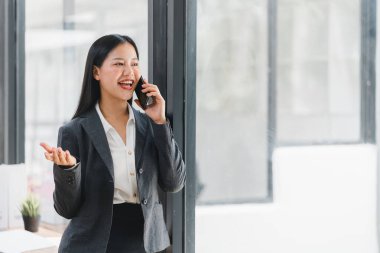 Profesyonel bir kadın telefonda konuşuyor, gülümsüyor ve sohbet ediyor.