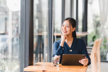 Tabletle masada oturmuş eğlenen bir kadın..