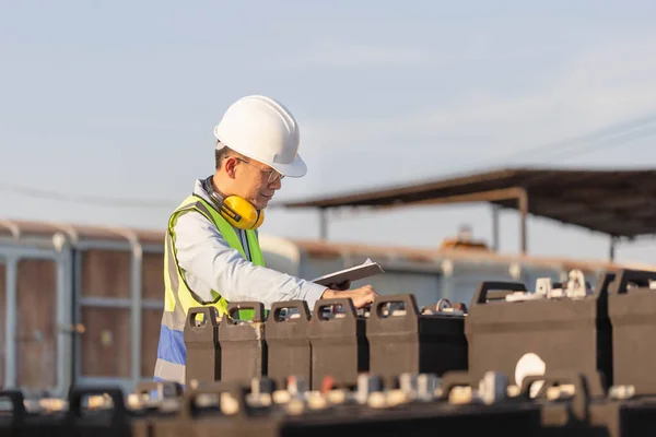 Mechanical worker checking of the battery storage system, Engineer man in waistcoats and hardhats with clipboard checklist inspecting construction site