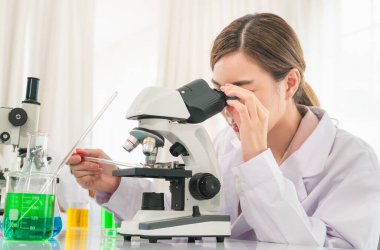 Tıp laboratuarında plastik tıp tüpleriyle çalışan kadın araştırmacı, doktor, bilim adamı veya laboratuvar asistanı