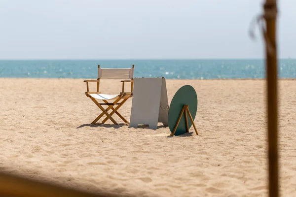 Directors chair and blank outdoor stand mockup poster display on the beach